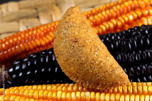 Obraz na płótnie Cornmeal mush pastry served on ears of corn of various colors.