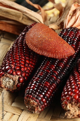 Cornmeal mush pastry served on ears of corn of various colors.