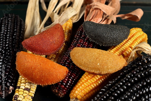 Cornmeal mush pastry served on ears of corn of various colors.