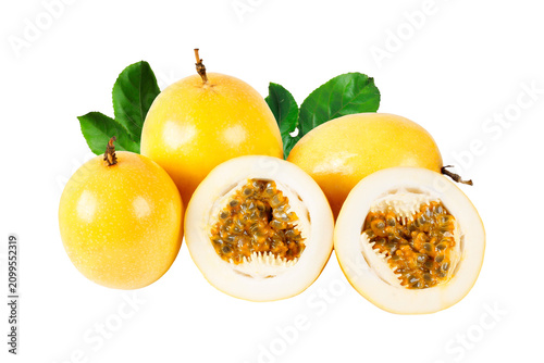 Group of fresh yellow passion fruits with sliced halves revealing aromatic pulp and seeds, decorated with green leaves and isolated on a white background