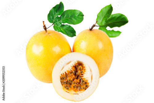 Two fresh yellow passion fruit with one sliced half showing juicy pulp and seeds, arranged with green leaves and isolated on a white background