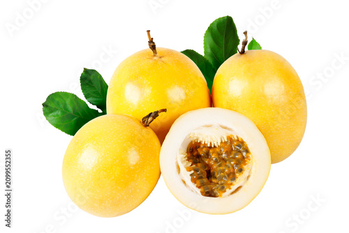Fresh yellow passion fruits with one sliced fruit displaying natural pulp and seeds, arranged with vibrant green leaves and isolated on a white background