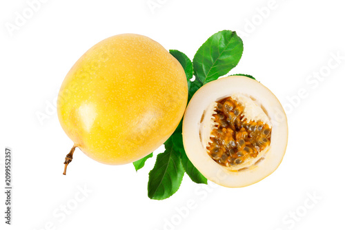 Whole yellow passion fruit with sliced half revealing aromatic pulp and seeds, complemented by fresh green leaves and isolated on a white background