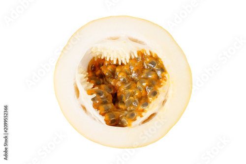 Close up of a sliced yellow passion fruit showing fresh pulp and seeds isolated on a white background