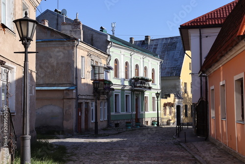 Historic cobblestone street with colorful old buildings under clear blue sky