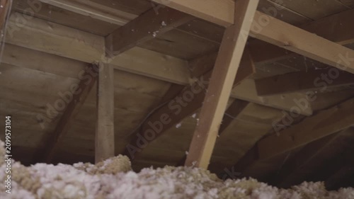 This panning video shows a residential attic filled with fresh new insulation.