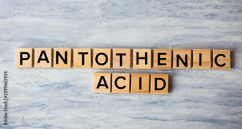 Bild auf Leinwand Pantothenic Acid Concept Spelled with Wooden Blocks on Marble Surface