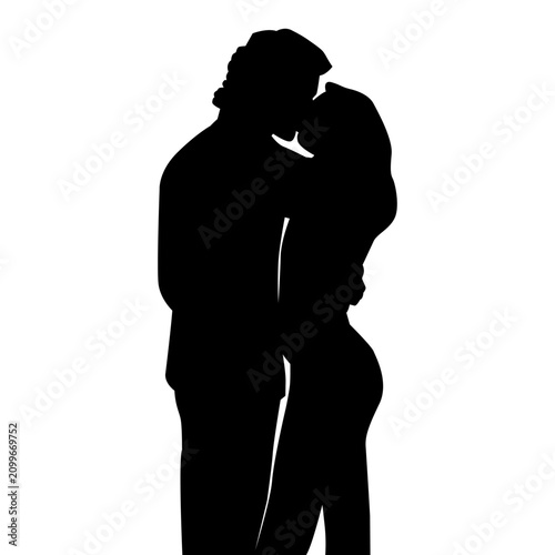 Romantic silhouette of a young couple is kissing while embracing.