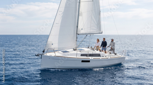 Sailboat with three people on open water