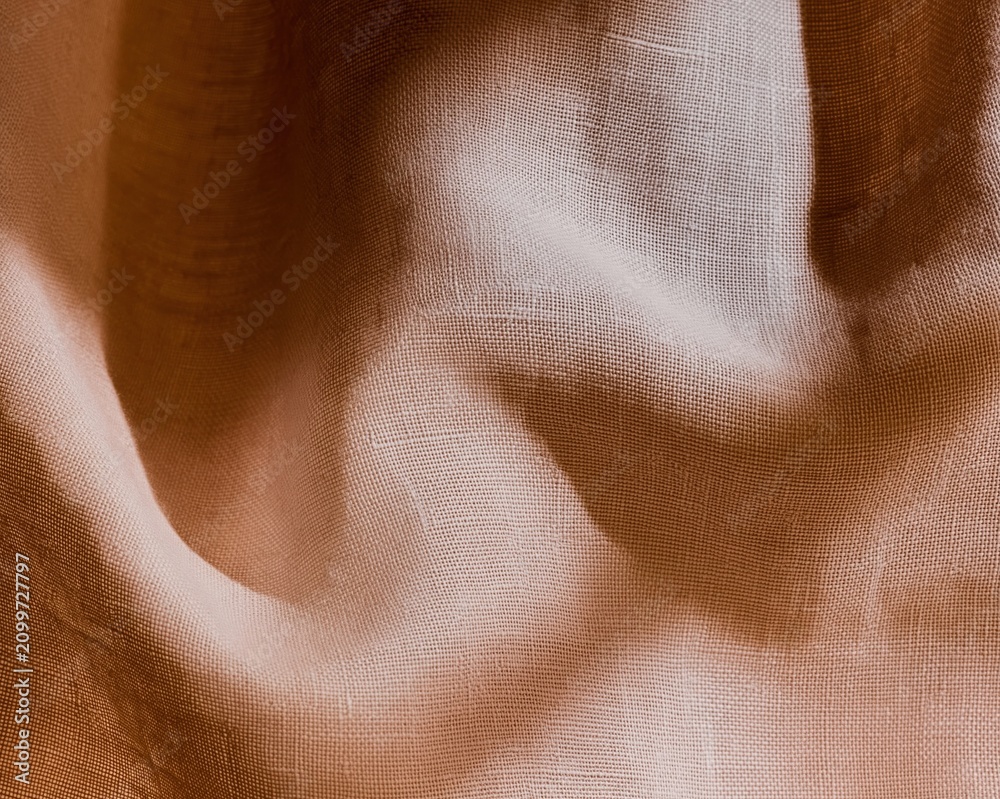 Fototapeta premium Close up of textured linen fabric with deep folds and shadows, showing a tactile woven surface for interior design and textile styling