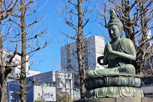 Foto Bronze statue of Kannon Bodhisattva in a Japanese urban temple garden