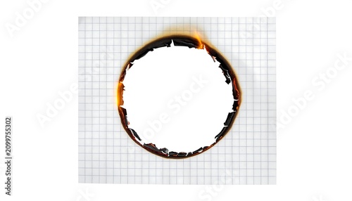 Circular burnt hole in white graph paper with charred edges creating a unique industrial frame on grid