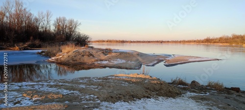 Fotografía Scenic Winter Landscape of the Vistula River with Snow-Covered Banks and Bare Tr