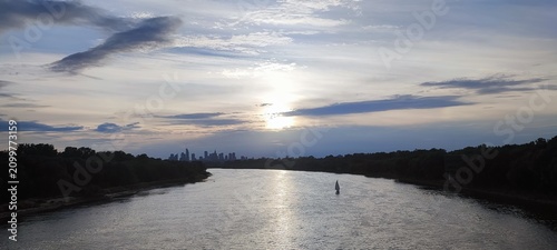 Fotografie Scenic Sunset Over Vistula River with Warsaw Skyline in the Distance