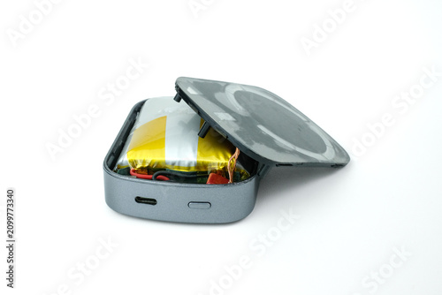 An opened power bank reveals a swollen lithium battery and internal electronic components on a white background. Suitable for opened power bank damage, battery failure, lithium battery swelling