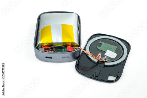 An opened power bank shows a swollen lithium battery, exposed wires, and separated casing parts on a white background. Suitable for battery swelling, damaged power bank, lithium battery hazard