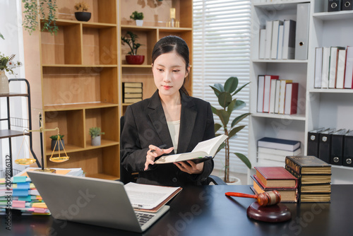 Attractive young lawyer in office Business woman and lawyers discussing contract papers with brass scale on wooden desk in office. Law, legal services, advice, Justice and real estate concept.