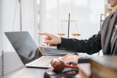 Fotografie Young lawyer in office Business woman and lawyers discussing contract papers with brass scale on wooden desk in office