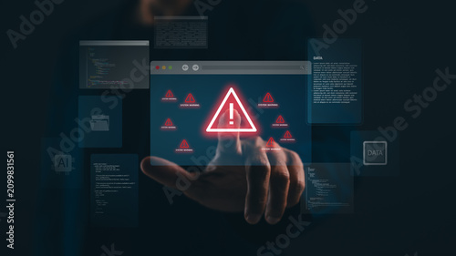 A finger points at a digital warning sign on a screen surrounded by code and data, symbolizing cybersecurity threats or system errors.