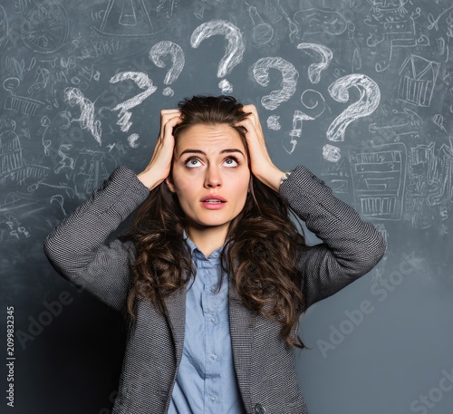 Woman in Business Attire Stressed with Question Marks Overhead