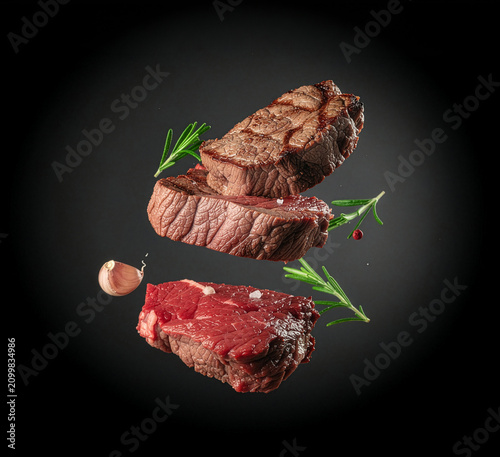 Grilled beef steaks in motion with rosemary on dark background in the air. Generative AI