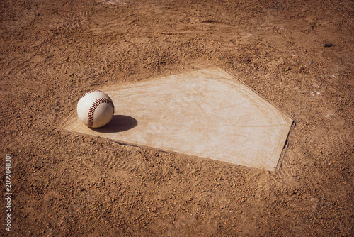 Baseball sitting on home plate of sports field