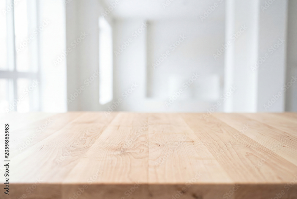 Obraz premium Empty wooden table surface with blurred white room background for product display