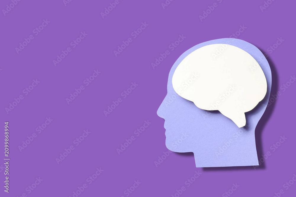 Fototapeta premium Purple backdrop shows paper cutout of head and brain