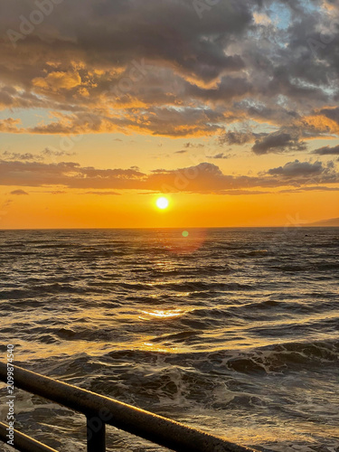 Breathtaking sunset horizon above the sea with warm reflections and dramatic cloud formations