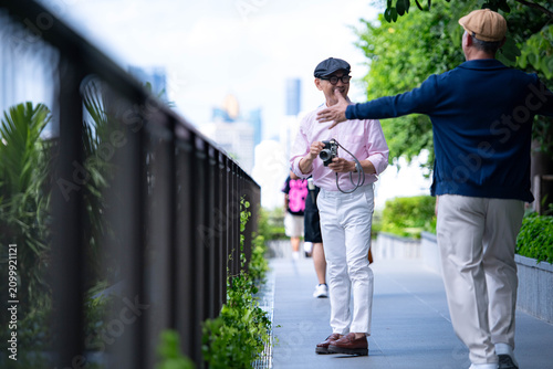 Canvas Print Senior gay couple reuniting during a city walk, sharing a warm greeting