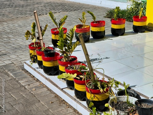 Fotografía Colorful recycled tire planters with ornamental plants decorating the entrance o