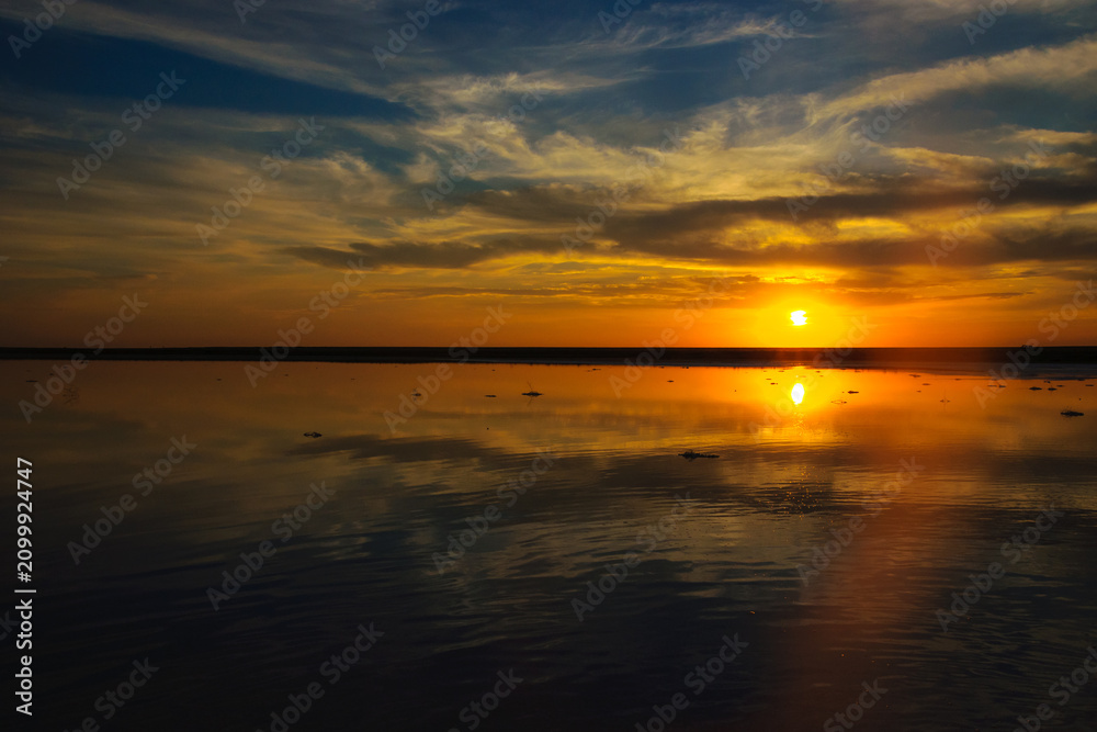 Obraz premium Wide Panoramic Golden Sunset Sky Reflection on Calm Lake Water Horizon Dramatic Cloud Evening