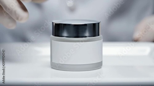 Cosmetic Cream Jar Held by Gloved Hand in Professional Laboratory Setting for Skincare and Health Applications