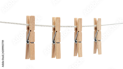 Four wooden clothespins hanging on a thin white rope against a clean white background