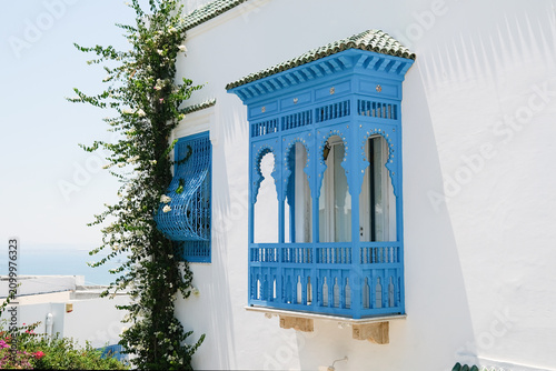 White Building with Blue Shutters and Bougainvillea in Mediterranean Town