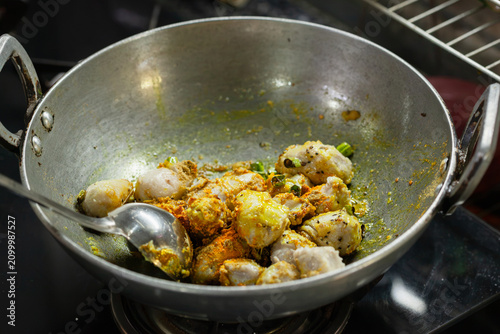 Indian style taro root curry being cooked in a wok