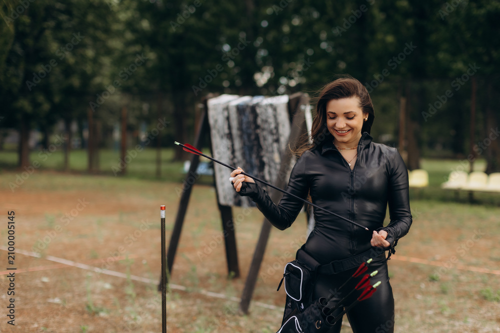 Fototapeta premium Woman preparing arrow for archery training session