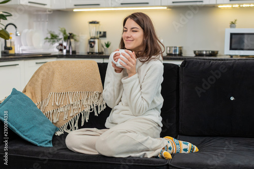 Fotografía Young woman at home makes herbal tea holds warm cup takes slow sip and rests in quiet mood