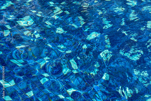 Принти на полотні Sunlit ripples create vivid abstract patterns across clear blue swimming pool water