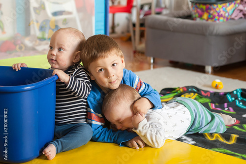 Fotografía Three brothers share a tender moment of connection while playing together on a s