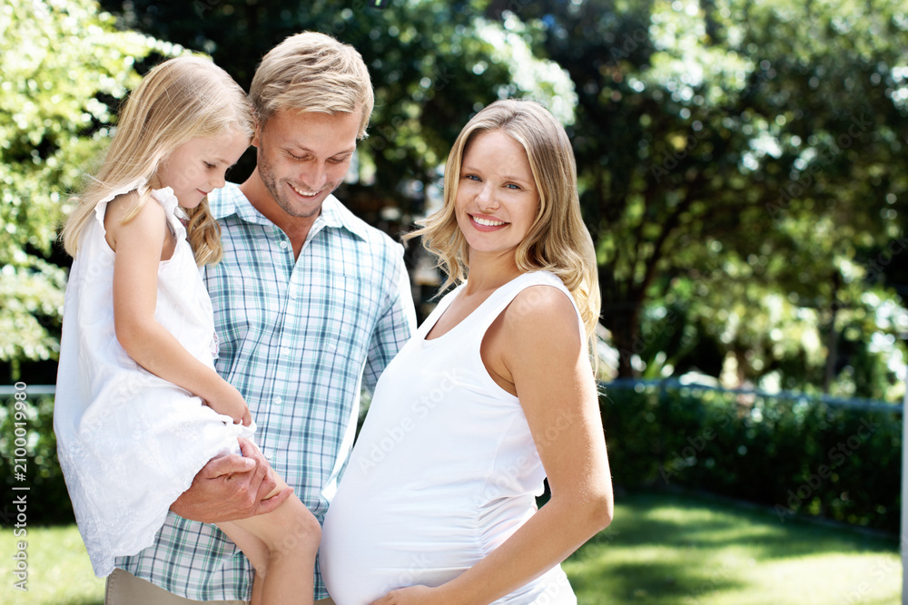 Naklejka premium Smile, father and child in nature with pregnant woman, love and summer holiday for bonding together. Portrait, parents and happy at park with daughter, maternity and weekend break for family vacation