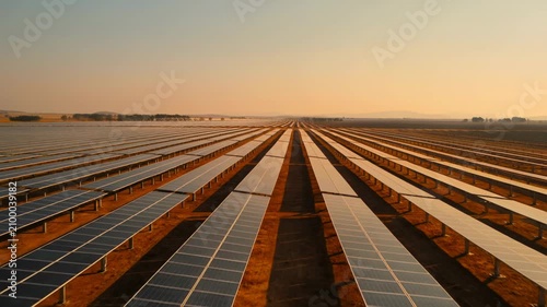 Aerial view of vast solar panel farm at golden hour, renewable energy concept