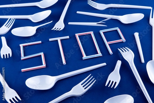 фотографія Stop word made of straws with plastic cutlery on blue background for environment