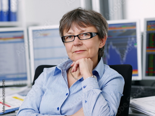 Concentrated Individual Analyzing Data on Computer at Tidily Arranged Workstation with Soft Ambient Lighting, Conveying Focus and Persistence