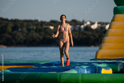 Girl having fun on inflatable water park obstacle