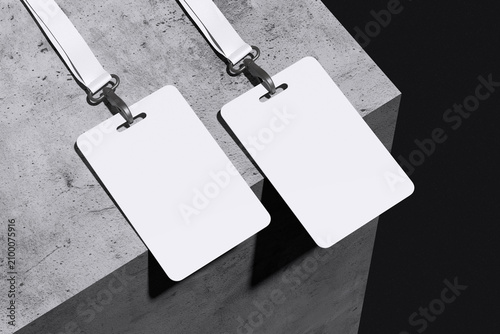 Two white ID card badge with lanyard on concrete and black background for mockup template