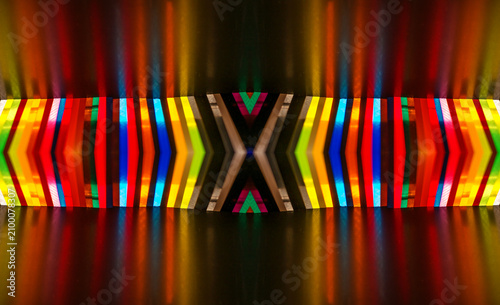 a stacked arrangement of colored cast acrylic sheets illuminated from behind, creating vibrant light reflections