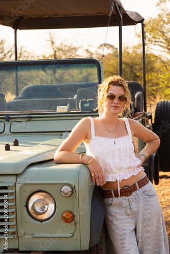 stylish young woman and vintage safari vehicle, Zambezi National Park, Zimbabwe, Africa