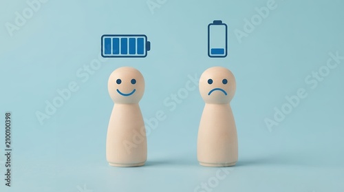 Mental health energy levels concept, wooden figures with battery charge icons, emotional burnout and wellness comparison on blue background