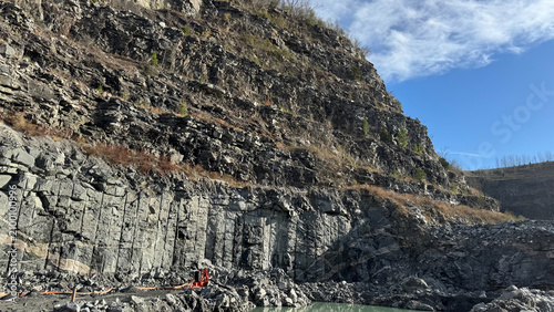 Foto Layered rock cliff beneath a bright blue sky